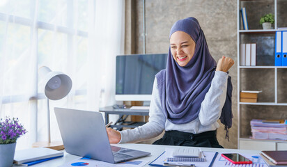 Obraz na płótnie Canvas Young muslim woman working in business office, wearing Hijab works as start up SMEs project, Success, win, glad, gleeful, cheerful, victory.