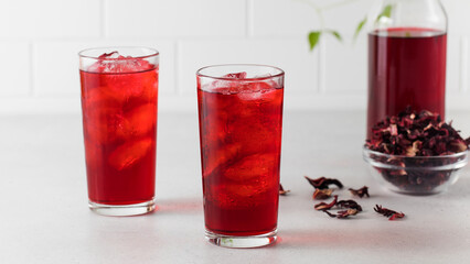 A refreshing drink made of dried hibiscus leaves and ice in a glass.