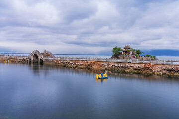 Fototapeta na wymiar Natural landscape of small island temples and ancient stone arch bridges on Erhai Lake in Yunnan Province, China