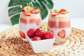 Glass of sweet delicious homemade layered smoothie dessert made from fruits and berries. delicious Strawberry banana milkshake, vegan raw food. Selective focus. Chia pudding