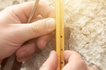 Metal guides for leveling the wall with concrete mortar, installation and fastening of metal guides.