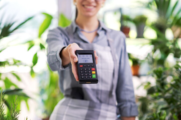 Professional florist holding a POS terminal