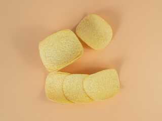 Potato chips on an orange background. Close-up.