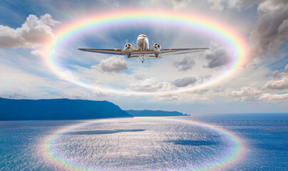 Old metallic propeller airplane in the sky with rainbow