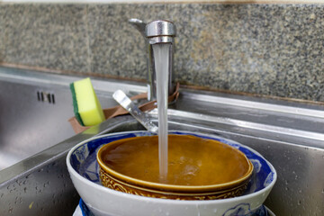 sink plate bowl tap sponge hand dirty