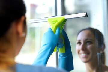 Woman washing windows at home