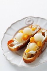 Homemade fruit and cream cheese French bread open sandwiches, white melon and mango