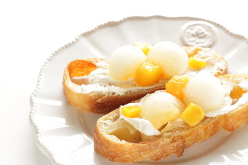 Homemade fruit and cream cheese French bread open sandwiches, white melon and mango