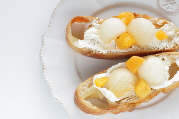 Homemade fruit and cream cheese French bread open sandwiches, white melon and mango