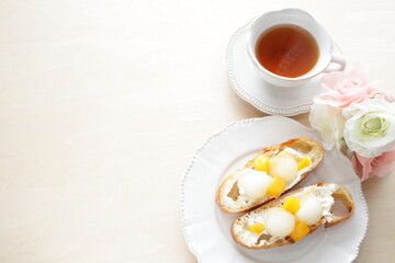 Fototapeta na wymiar Homemade fruit and cream cheese French bread open sandwiches, white melon and mango with English black tea