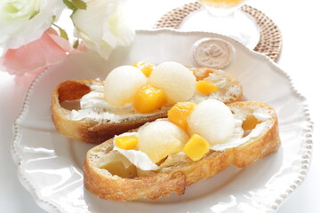 Homemade fruit and cream cheese French bread open sandwiches, white melon and mango