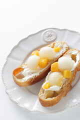 Homemade fruit and cream cheese French bread open sandwiches, white melon and mango