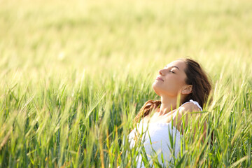 Relaxed woman sitting in a field breathing