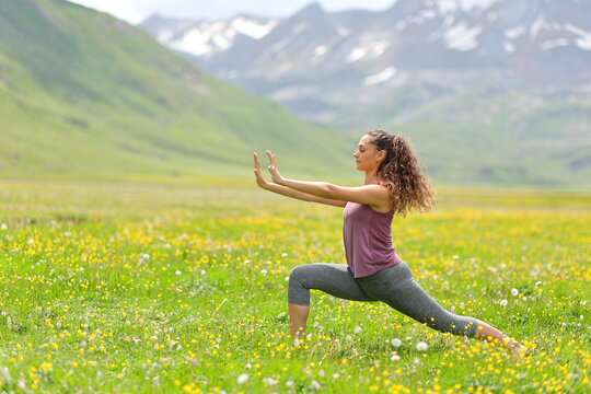 Woman practicing tai chi in a high mountain field