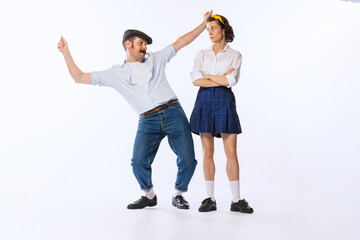 Portrait of young stylish woman looking at dancing cheerful man isolated over white studio background