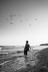 Walking away with a chair. Girl in formal elegant stylish suit, shirt and hat walking barefoot...