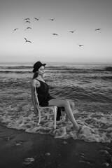 sea and girl. romantic black and white original aesthetics vertical composition. girl in black...
