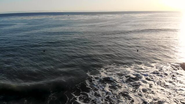 Cambria Beach Surfers Drone Footage at Sunset. California surfing aerial video at pacific coast. Gentle waves rolling.