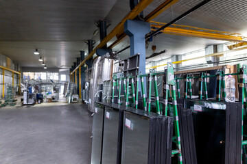 Factory for the production of double-glazed windows made of sheet glass. Ready-made double-glazed windows are on pallets.
