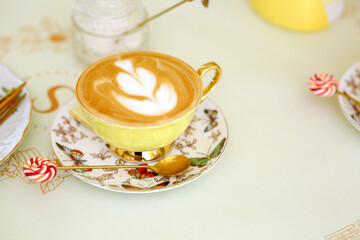 Banner with an elegant yellow porcelain cup with natural coffee with a pattern. Coffee house. Cozy restaurant. Good morning concept.