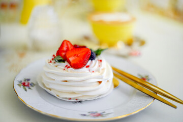 Sweet meringue dessert close-up decorated with strawberries, blackberries and red currants. Birthday. Holiday concept.