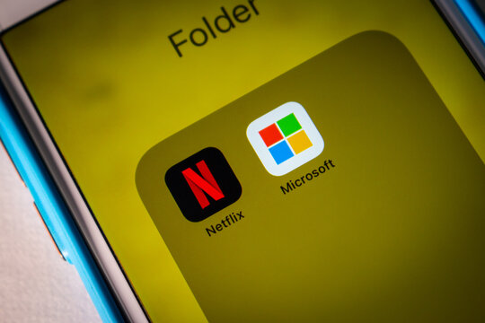Kumamoto, JAPAN - July 17 2022 : Netflix and Microsoft icons on an iPhone in a dark mood. In July 2022, Netflix announced a partnership with Microsoft for Ad-Supported Subscription