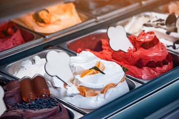 Ice cream of various colors and flavors in the refrigerator in the window of a dessert shop or gelateria in Italy. Delicious and tasty gelato in cafe
