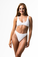 Obraz premium Smiling sporty woman in white underwear posing on studio background with copy space. Female beauty, sport, spa concept
