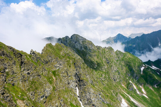 beautiful fagaras ridge on a sunny morning. popular destination in mountain range of romania. rocky cliffs and clouds in morning light. wonderful nature background