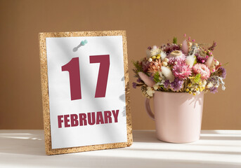 february 17. 17th day of month, calendar date.Bouquet of dead wood in pink mug on desktop.Cork...