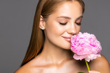 young beautiful woman with pink flower on white background