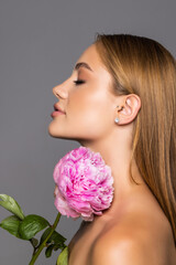 Skincare of young beautiful woman face with fresh flower over white background