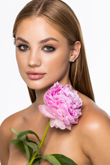 Naklejka premium Beauty face of the young beautiful woman with flower on white background