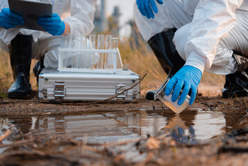 Ecologist taking samples of water with test tube from city river to determine level of contamination and pollution, Research conserve water and environment.