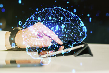 Double exposure of creative artificial Intelligence symbol with finger clicks on a digital tablet on background. Neural networks and machine learning concept