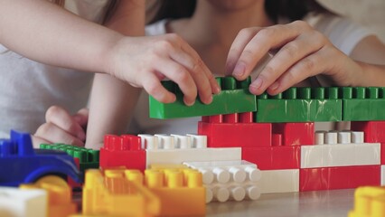 little child plays constructor with his mother. happy family. kid builds multi-colored Bricks tower. psychologist engaged child play activity. center preschool education. kid child kindergarten teacher.