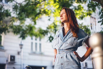 Portrait of a young beautiful woman on a summer street in the city at sunset