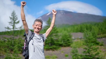 富士山背景に万歳をする男性　ガッツポーズ