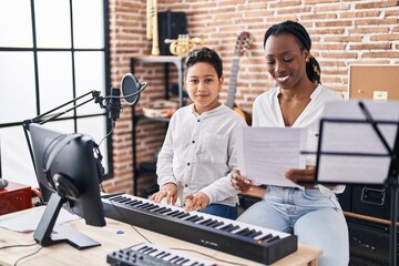 African american mother and son student learning play piano at music studio