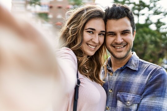 Young hispanic couple hugging in love at the city. Girlfriend and boyfriend together in love taking selfie picture