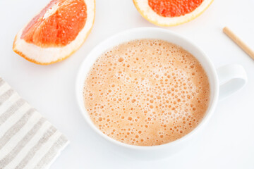 Fresh homemade grapefruit milkshake closeup. Smoothie made of citrus and milk or youghurt for detox diet. Summer drink in porcelain cup.