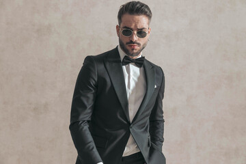 portrait of sexy bearded businessman with sunglasses and hand in pocket