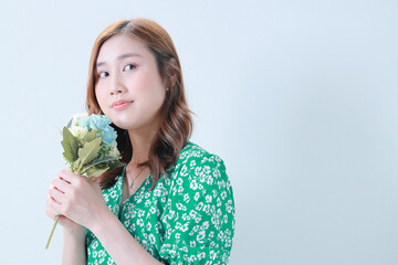 薔薇の花束を持ち遠くを見つめる若い女性