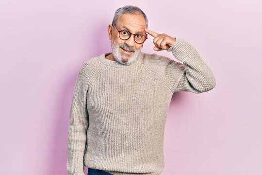 Handsome senior man with beard wearing casual sweater and glasses smiling pointing to head with one finger, great idea or thought, good memory