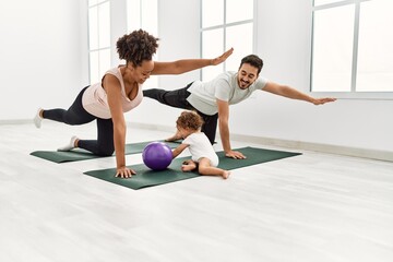 Obraz na płótnie Canvas Couple and daughter smiling confident training yoga at sport center