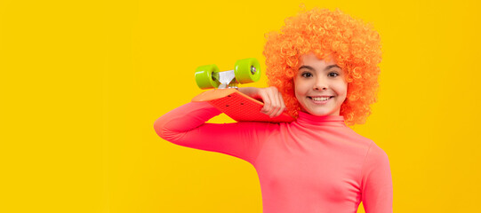 Happy girl child with orange hair in pink poloneck smile holding penny board, pennyboard. Funny teenager child on party, poster banner header with copy space.