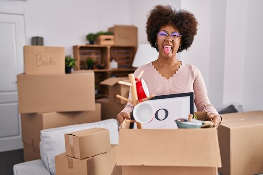 Young African American Woman Moving To A New Home Sticking Tongue Out Happy With Funny Expression.