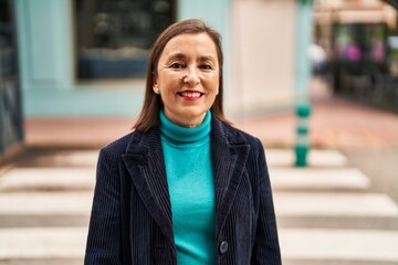 Middle age woman business executive smiling confident standing at street