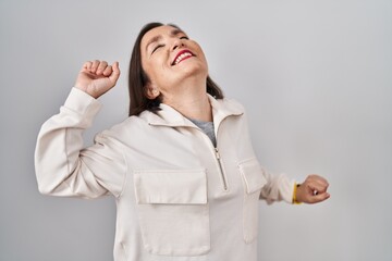 Middle age hispanic woman standing over isolated background stretching back, tired and relaxed, sleepy and yawning for early morning