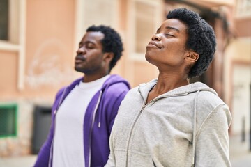 African american man and woman couple breathing at street